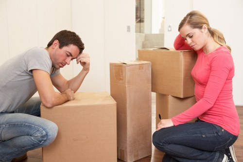 Movers carrying furniture through a narrow flat stairwell